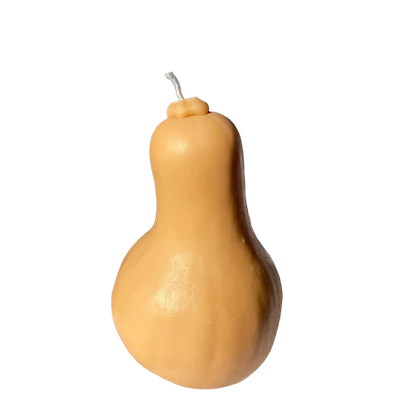 Realistic butternut squash shaped candle in natural tan and cream tones