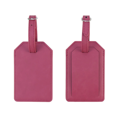 Custom pink vegan leather luggage tag shown attached to a travel suitcase