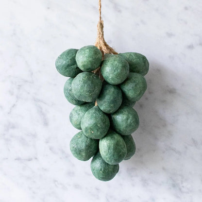 Olive-colored handcrafted soap shaped like a cluster of grapes on linen cloth