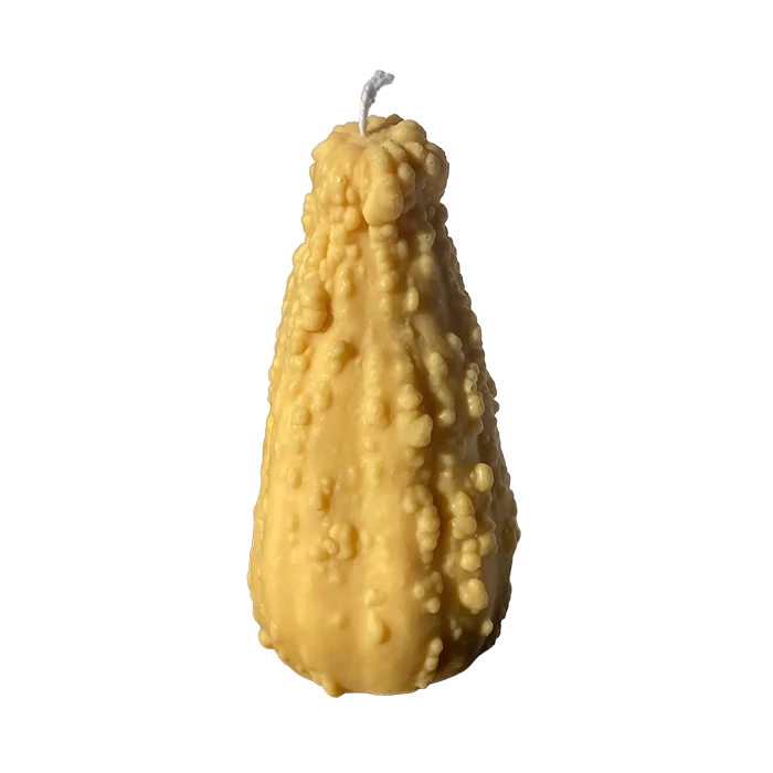 Realistic-looking crookneck gourd shaped candle in warm yellow and green tones