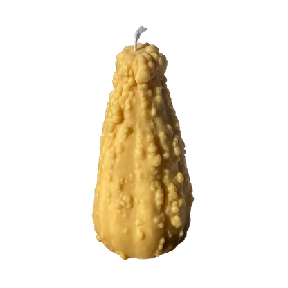 Realistic-looking crookneck gourd shaped candle in warm yellow and green tones